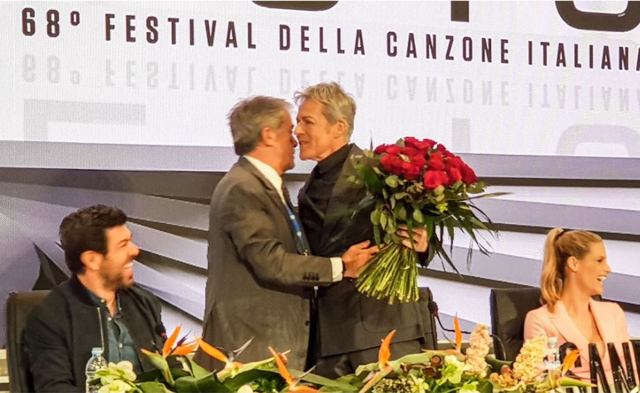 Sanremo 2018, conferenza stampa conclusiva in diretta. Teodoli: «Scommessa vinta con Baglioni». E ‘corteggia’ il cantante con un mazzo di rose