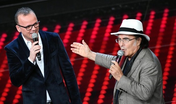 Il Cantante Mascherato: nella seconda semifinale i duetti con Albano e D’Alessio. Arrivano Pulcino e Gatta, Alba Parietti omaggia Mina